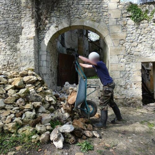 Décharge de pierres avec une brouette par un jeune